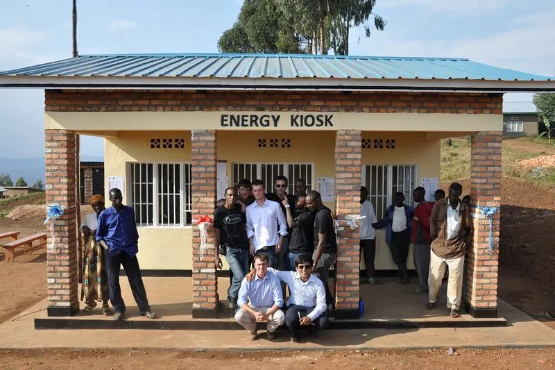 The e.quinox team and community members outside an Energy Kiosk in Rwanda