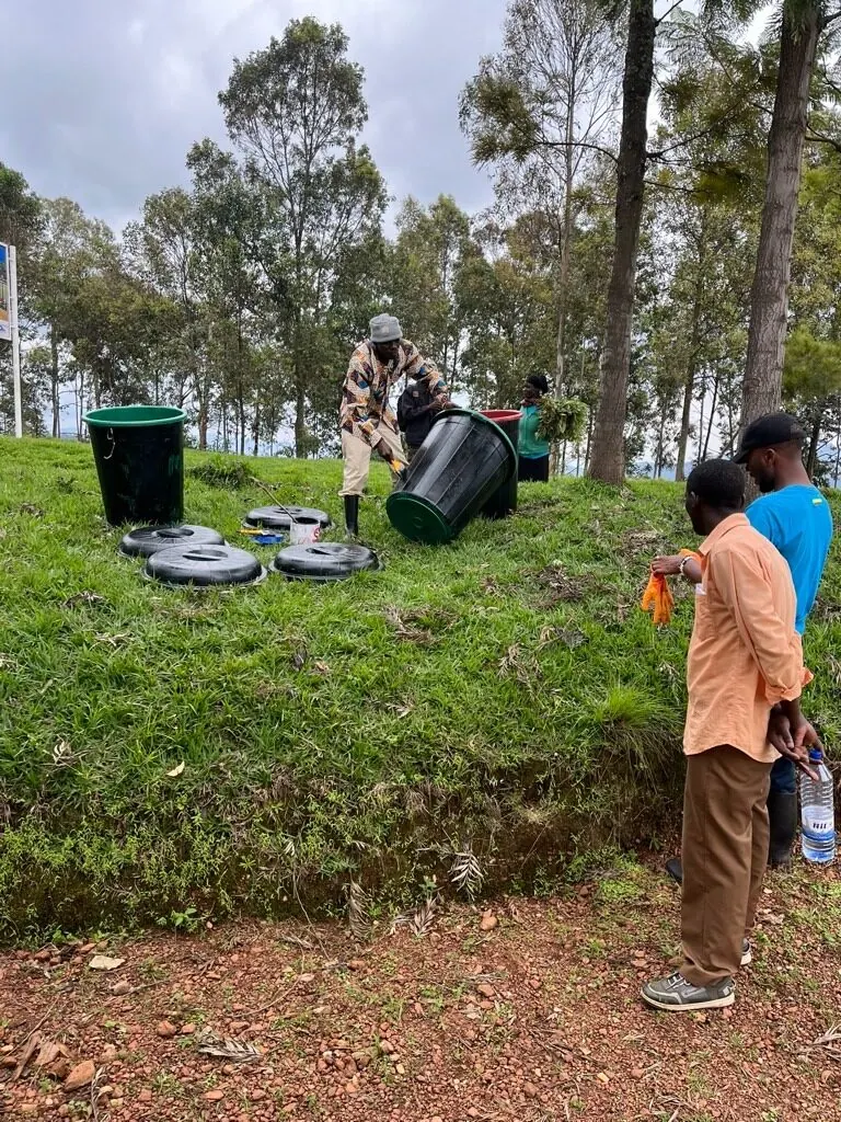 Community members gathered around Amazi tanks on a hillside