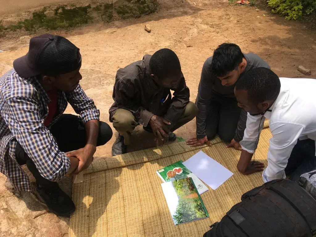 Team members and local partners working over a map on the ground